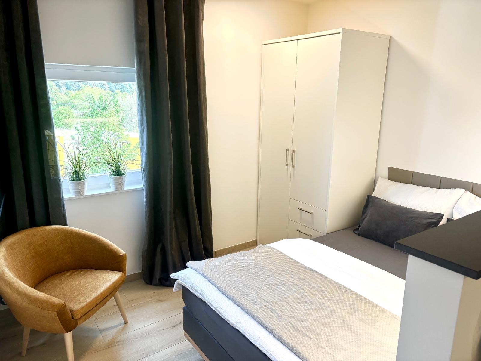 Heller Schlafbereich mit Sessel am Fenster
